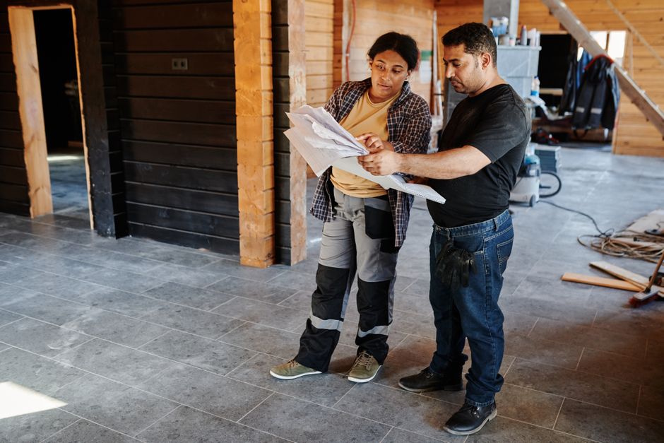 General contractor reviewing architectural blueprints on a job site